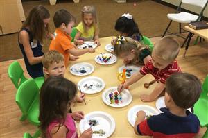 Group of young children at a table painting Group of young children at a table painting