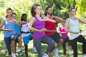 Coed group practicing tai chi in the park